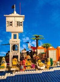 a group of people on a beach with a lifeguard tower