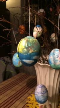 easter ornaments hanging from a branch on a table